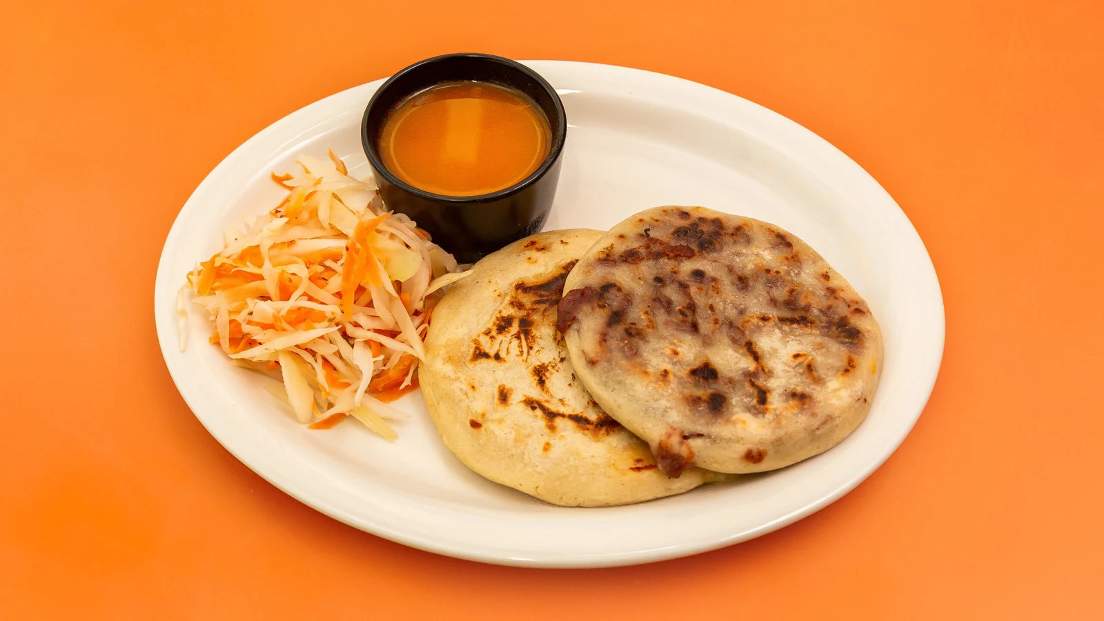 Handmade pupusas pictured with curtido and sauce